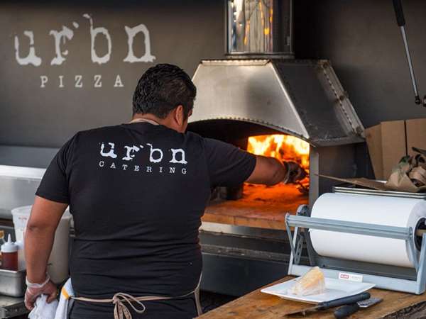 chef handling pizza in the oven